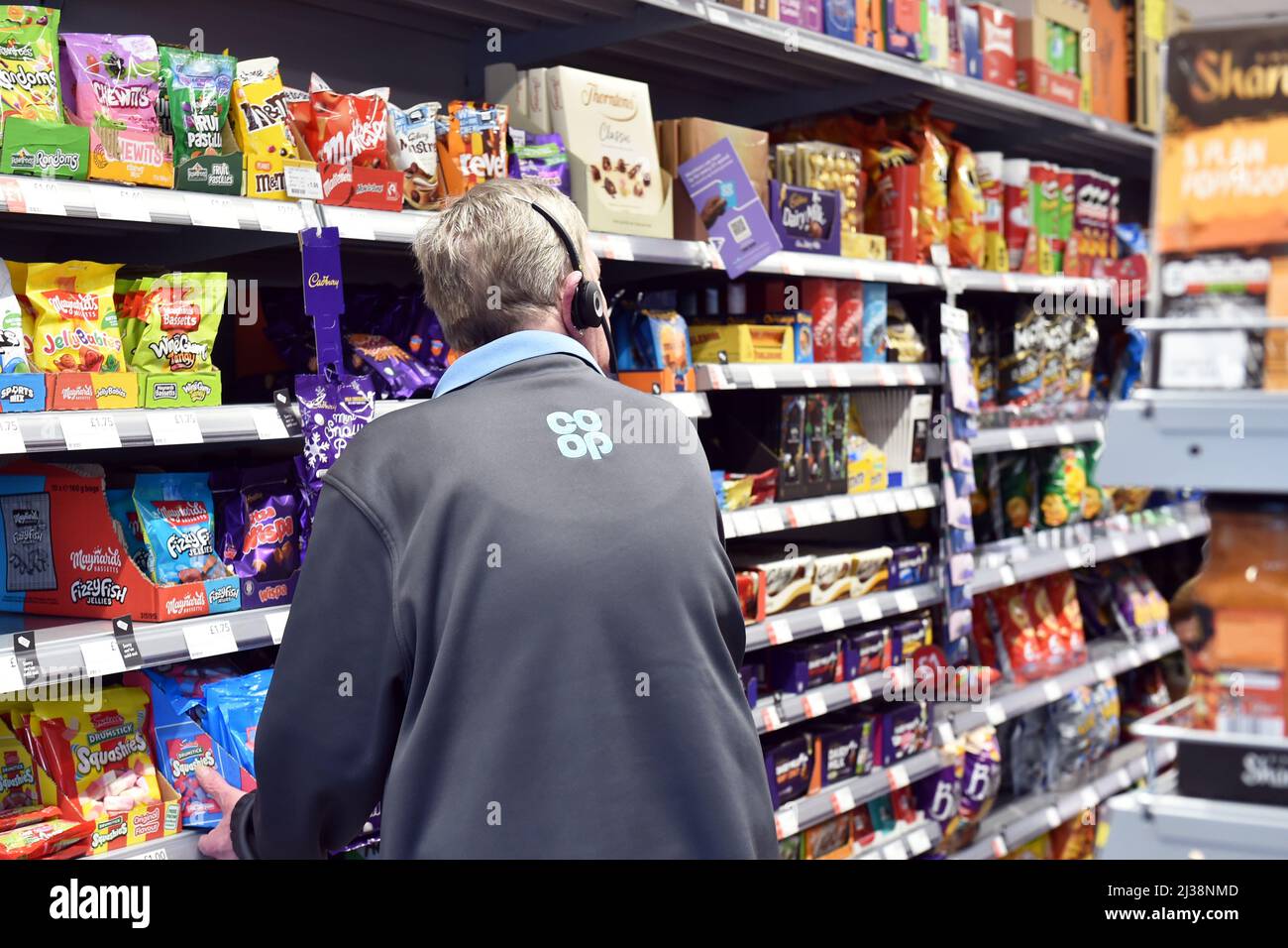 Il personale scaffali di magazzino in un supermercato UK Foto Stock