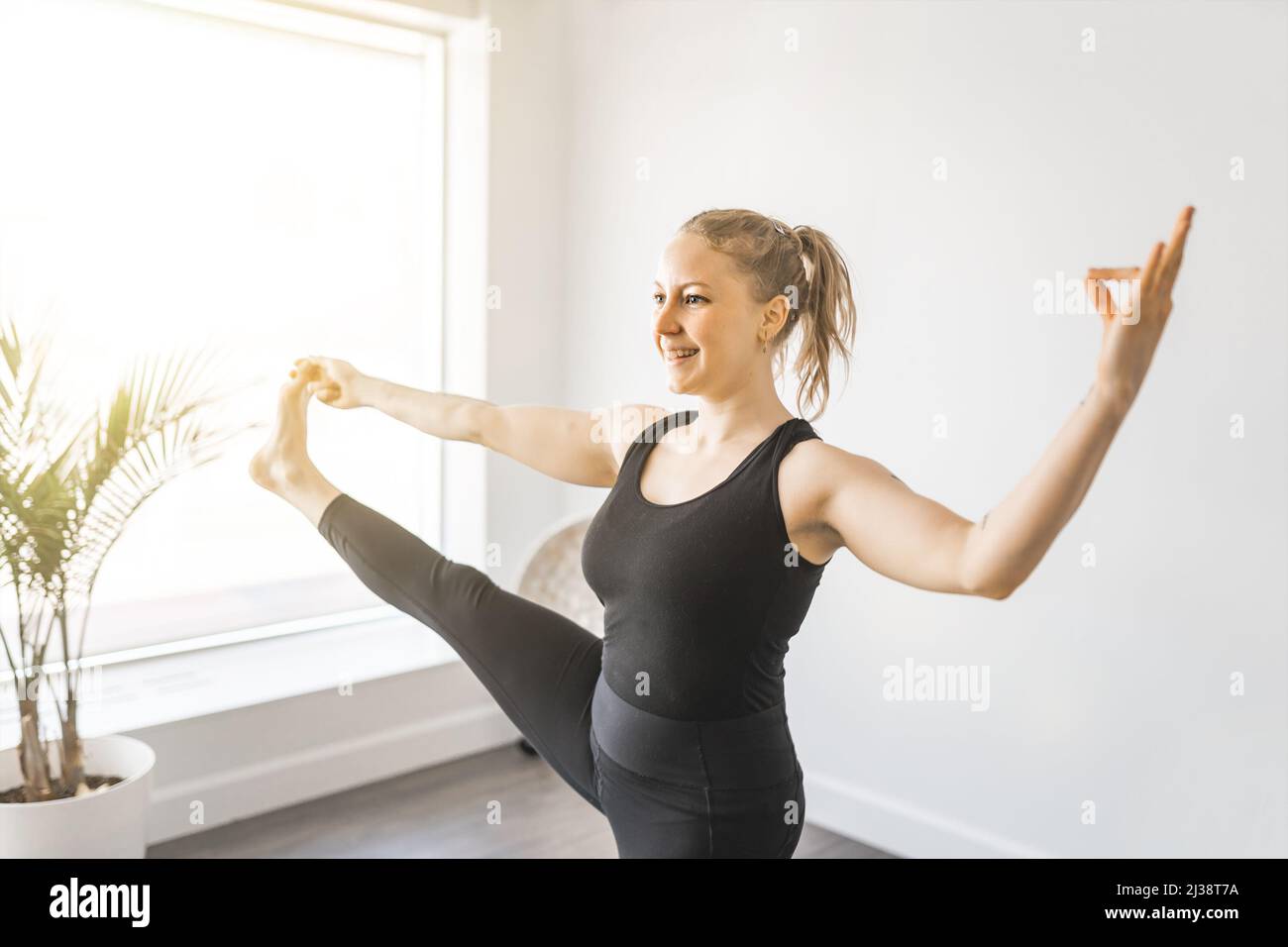 Giovane donna sportiva che pratica lo yoga e che ha un equilibrio naturale Foto Stock