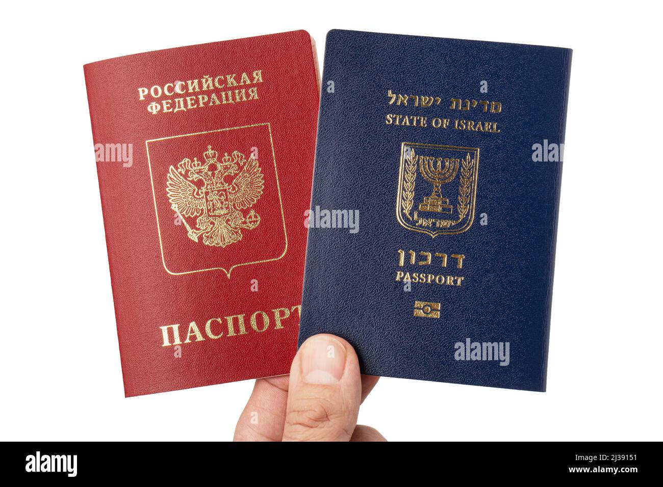 La mano maschile tiene i passaporti internazionali israeliani e russi isolati su sfondo bianco. Foto Stock