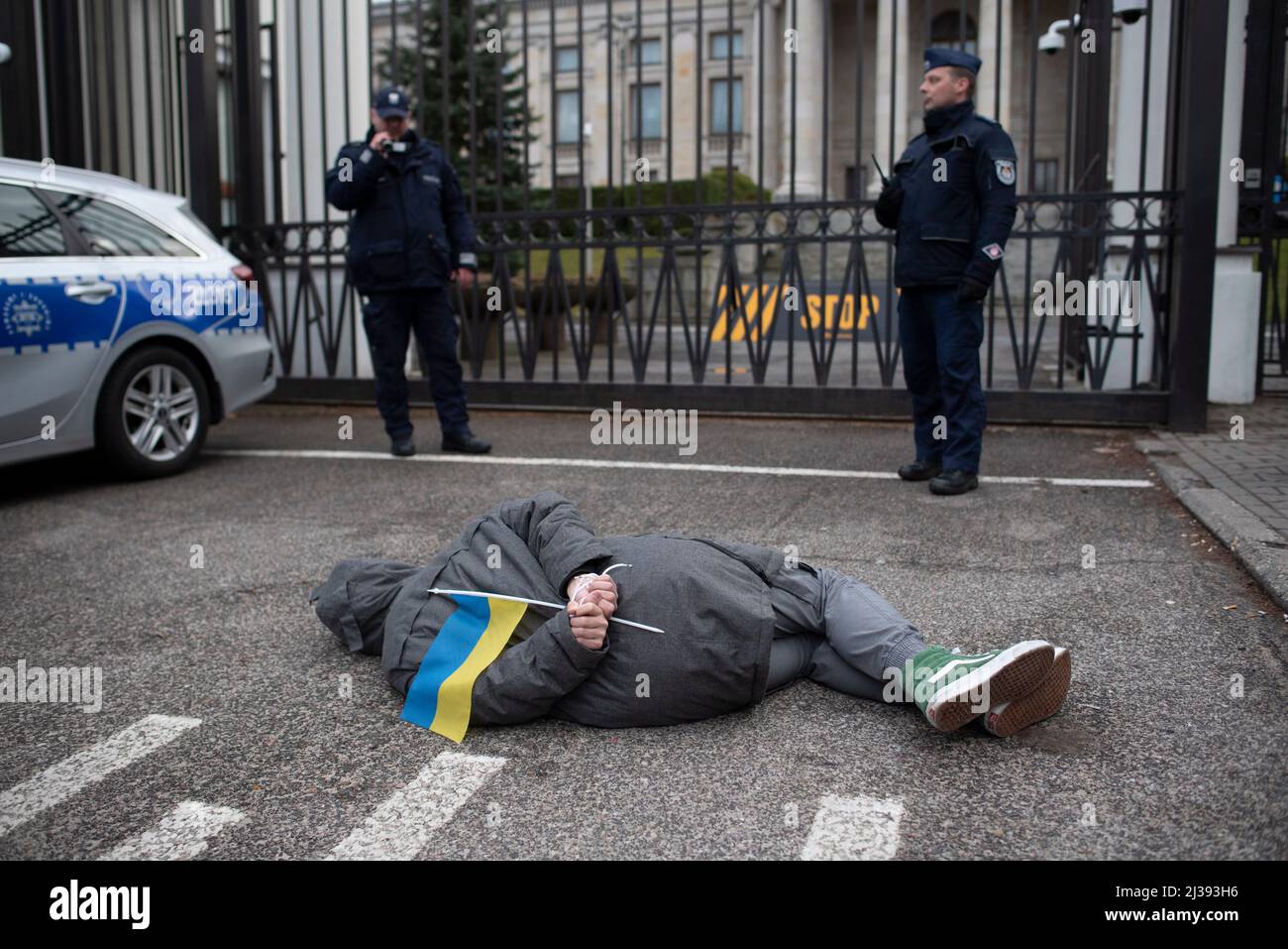 Varsavia, Polonia, Polonia. 6th Apr 2022. Un dimostratore si trova a terra con le mani legate dietro la schiena mentre protesta fuori dall'ambasciata russa il 6 aprile 2022 a Varsavia, in Polonia. Alcune decine di ucraini e i loro sostenitori si sono radunati fuori dall'ambasciata russa in una protesta silenziosa a seguito delle atrocità compiute dai soldati russi che si ritiravano dalla città Ucraina di Bucha. (Credit Image: © Aleksander Kalka/ZUMA Press Wire) Foto Stock