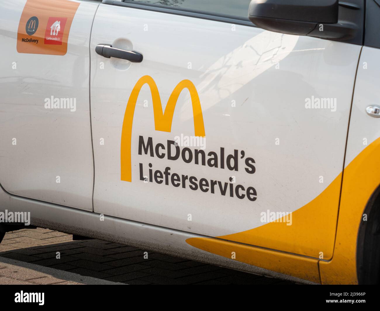 Logo del servizio di consegna McDonald's sulla parte esterna di un'auto. Cartello stampato sulla porta della macchina del ristorante. Ordinare alimenti veloci a casa vostra. Foto Stock