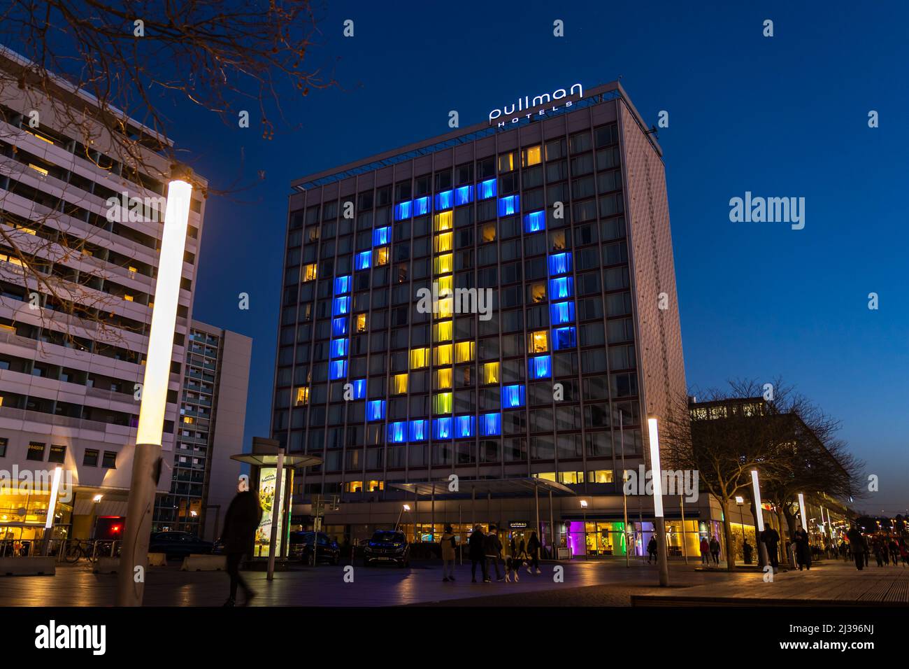Simbolo di pace nei colori ucraini blu e giallo. Le finestre illuminate dell'hotel Pullman mostrano solidarietà con l'Ucraina durante la guerra. Foto Stock
