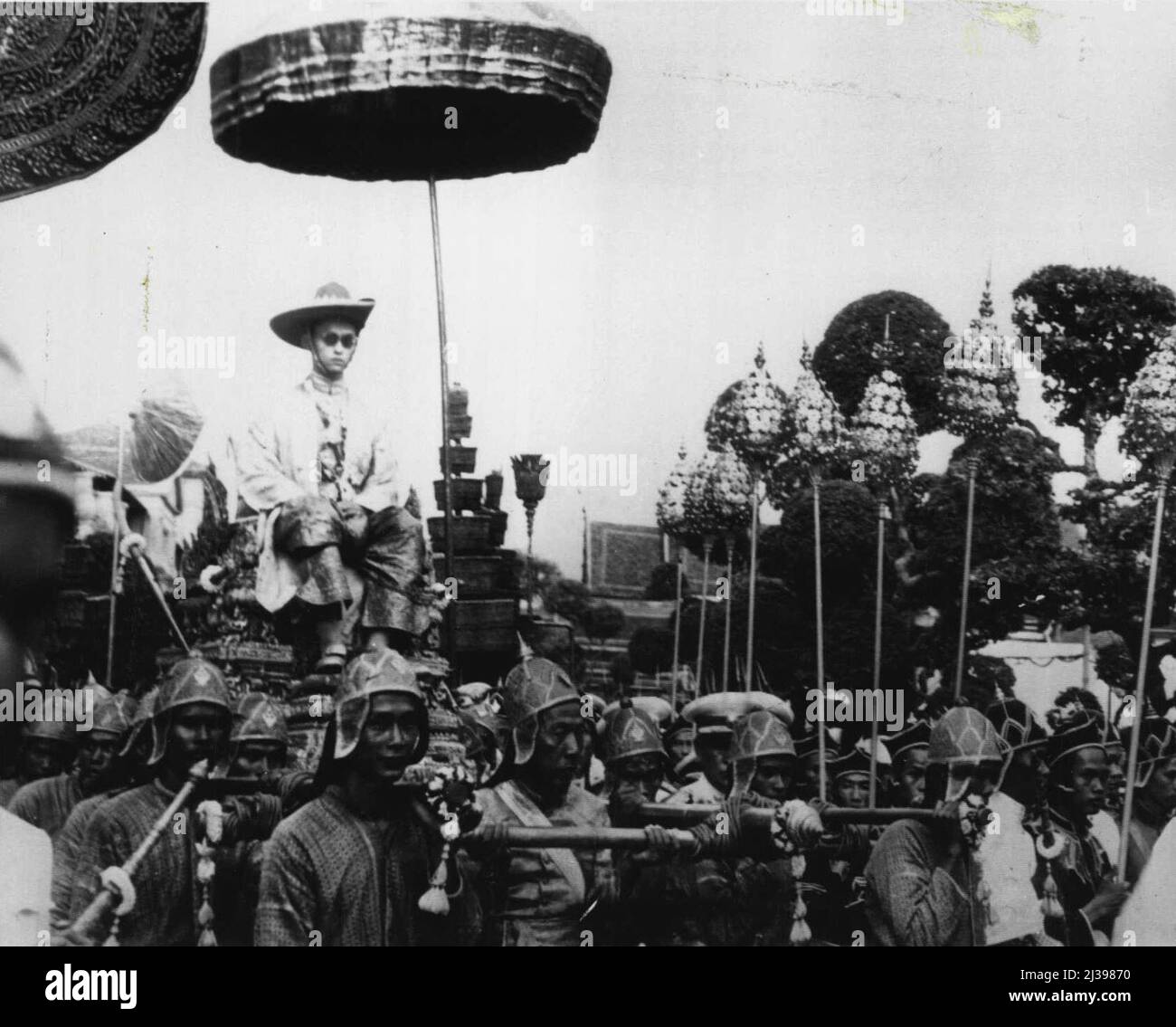 Oriental pomp Marks Thailand Coronatton -- Phumiphon Aduldet è sopportato su un palanquin per rendere omaggio al Buddha di Smeraldo in un tempio all'interno del palazzo reale dopo aver assunto il titolo di re Rama nelle cerimonie di incoronazione a Bangkok, Thailandia maggio 5th. La pomp orientale ha segnato i riti, tenuti una settimana prima del 23rd compleanno del Re, una data scelta dagli astrologi reali. Maggio 8, 1950. (Foto di AP Wirephoto). Foto Stock