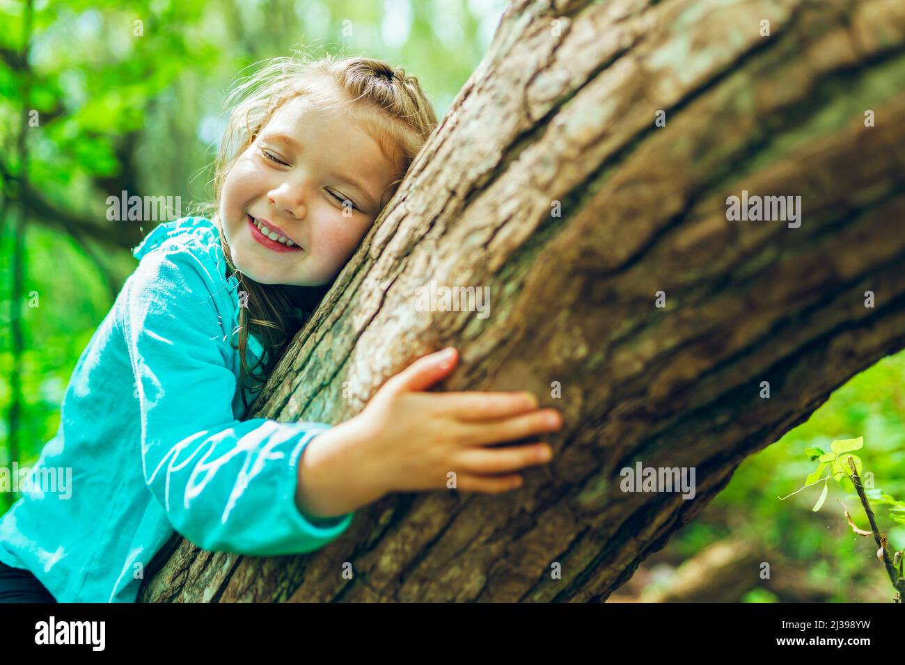 bambina su albero in estate sulla natura bambina Foto Stock