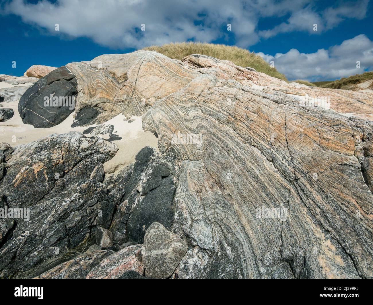 Bella formazione di roccia colorata a fasce di Gneiss Lewisian sulla spiaggia di Traigh Mheilein vicino a Hushinish sull'isola di Harris, Scozia, Regno Unito Foto Stock