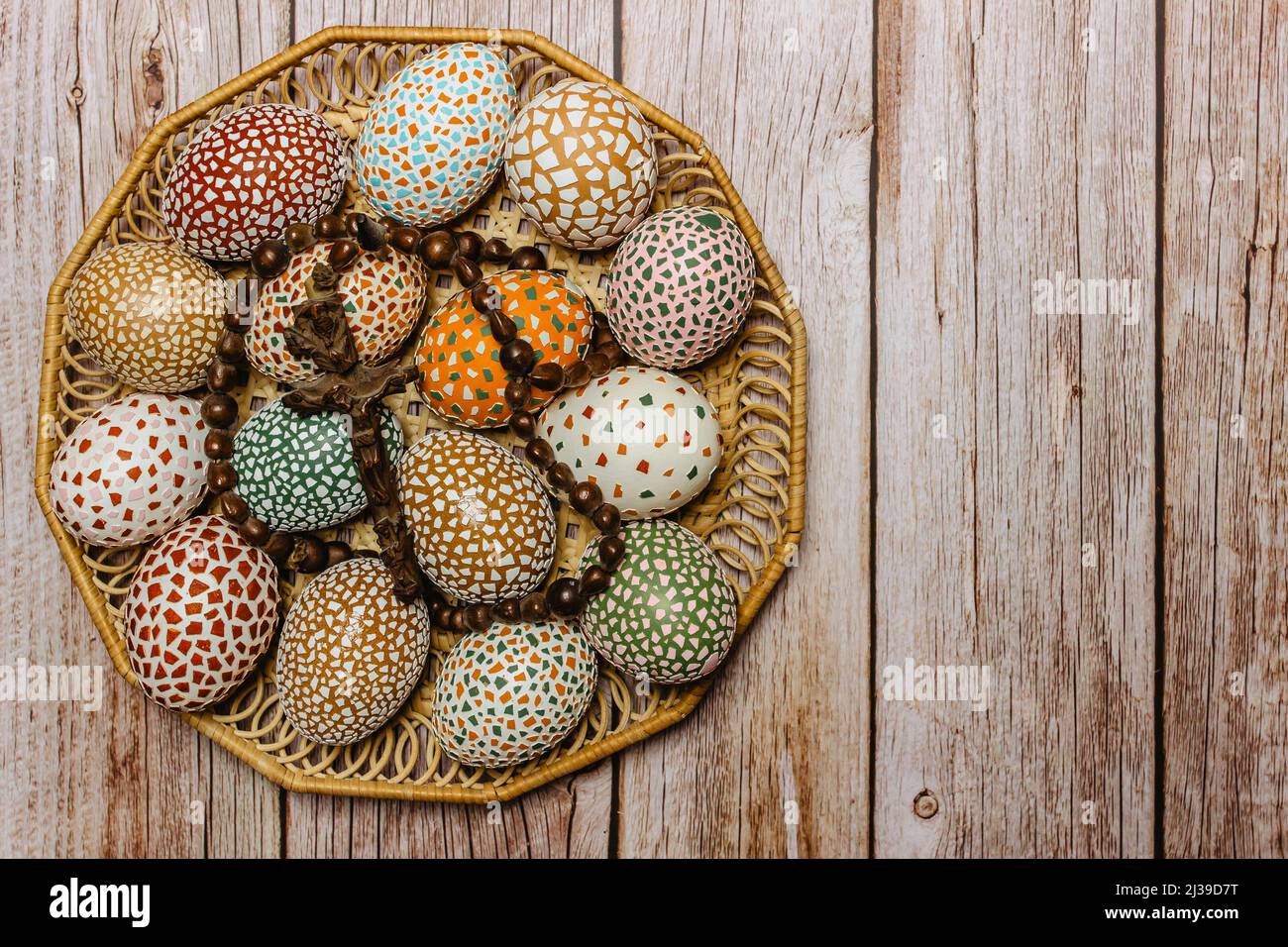 Happy Easter.colorful fatto a mano uova di Pasqua con crocifisso in legno cesto copia spazio per text.Spring decorazione sfondo. Tradizione festosa Foto Stock