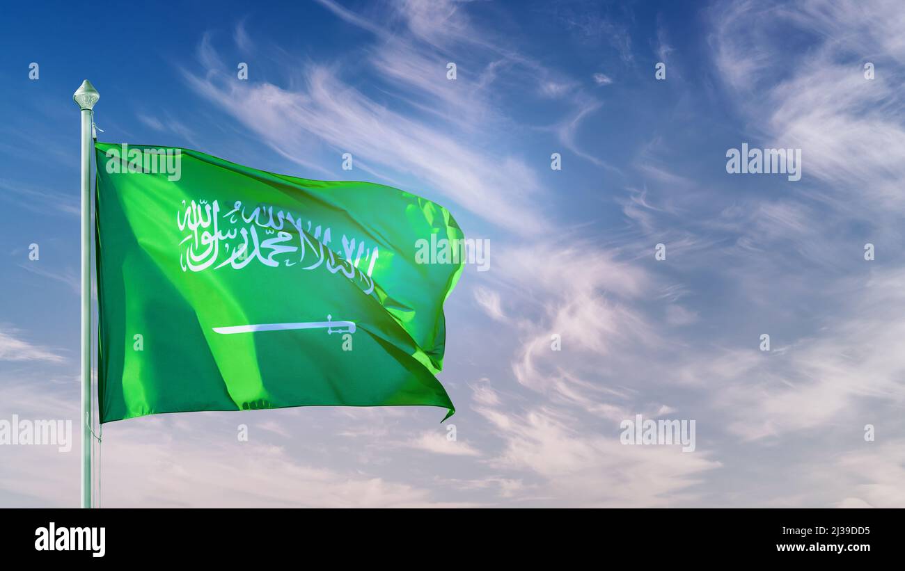 Bandiera dell'Arabia Saudita sul palo contro la vista panoramica del cielo blu. Copiare lo spazio sul cielo Foto Stock
