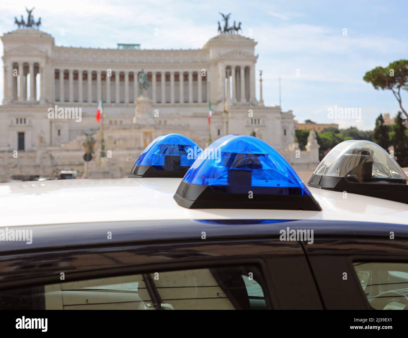 Luci blu lampeggianti della macchina della polizia italiana a Roma e sullo  sfondo il monumento chiamato altare della patria con le bandiere tricolore  nazionali Foto stock - Alamy