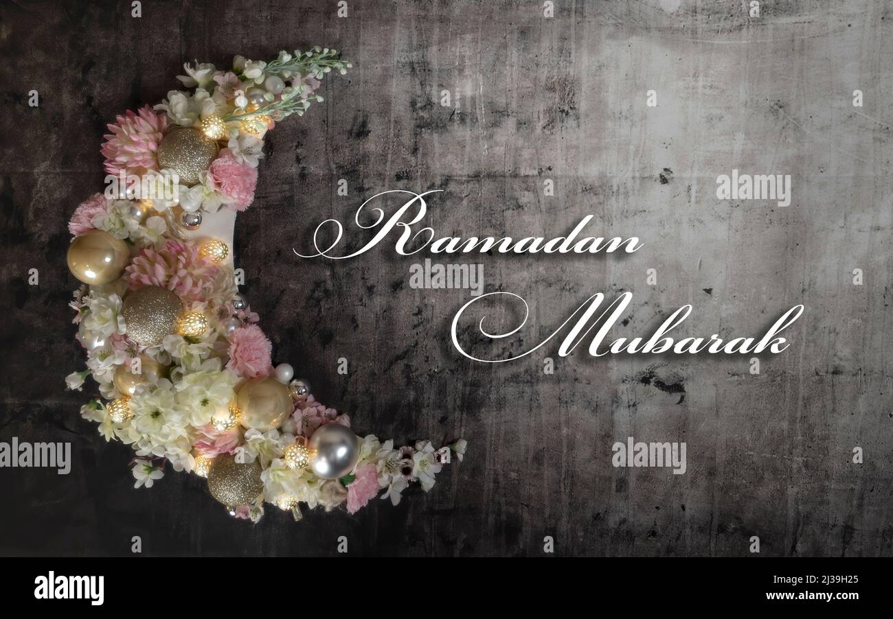 Ramadan Mubarak scrittura e mezzaluna di Ramadan coperto di fiori e illuminato. Foto Stock
