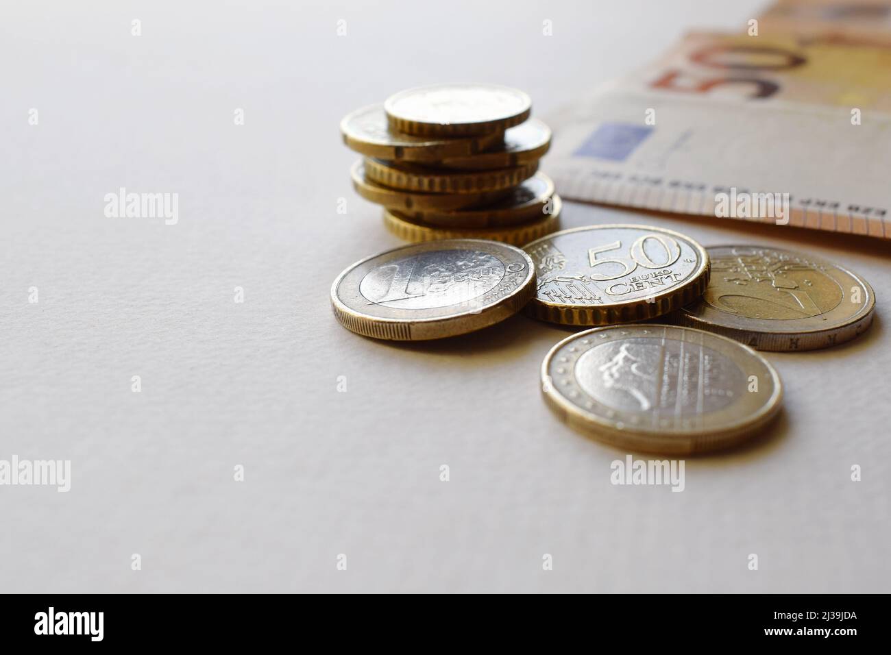 Concetto di banconote e monete in euro su sfondo bianco. Moneta europea. Monete da 1 euro, 2 euro e centesimi. 50 banconote in euro Foto Stock