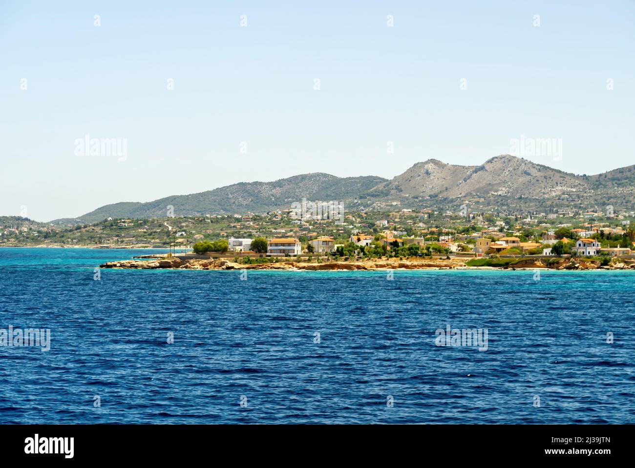 Vista dal ponte del traghetto durante la navigazione in Grecia, l'isola greca di Egina sullo sfondo. Foto Stock