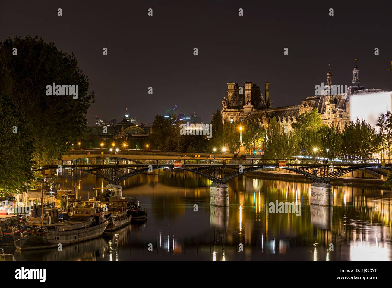 Parigi ed edifici storici di notte con riflessi sulla Senna con ponti Foto Stock