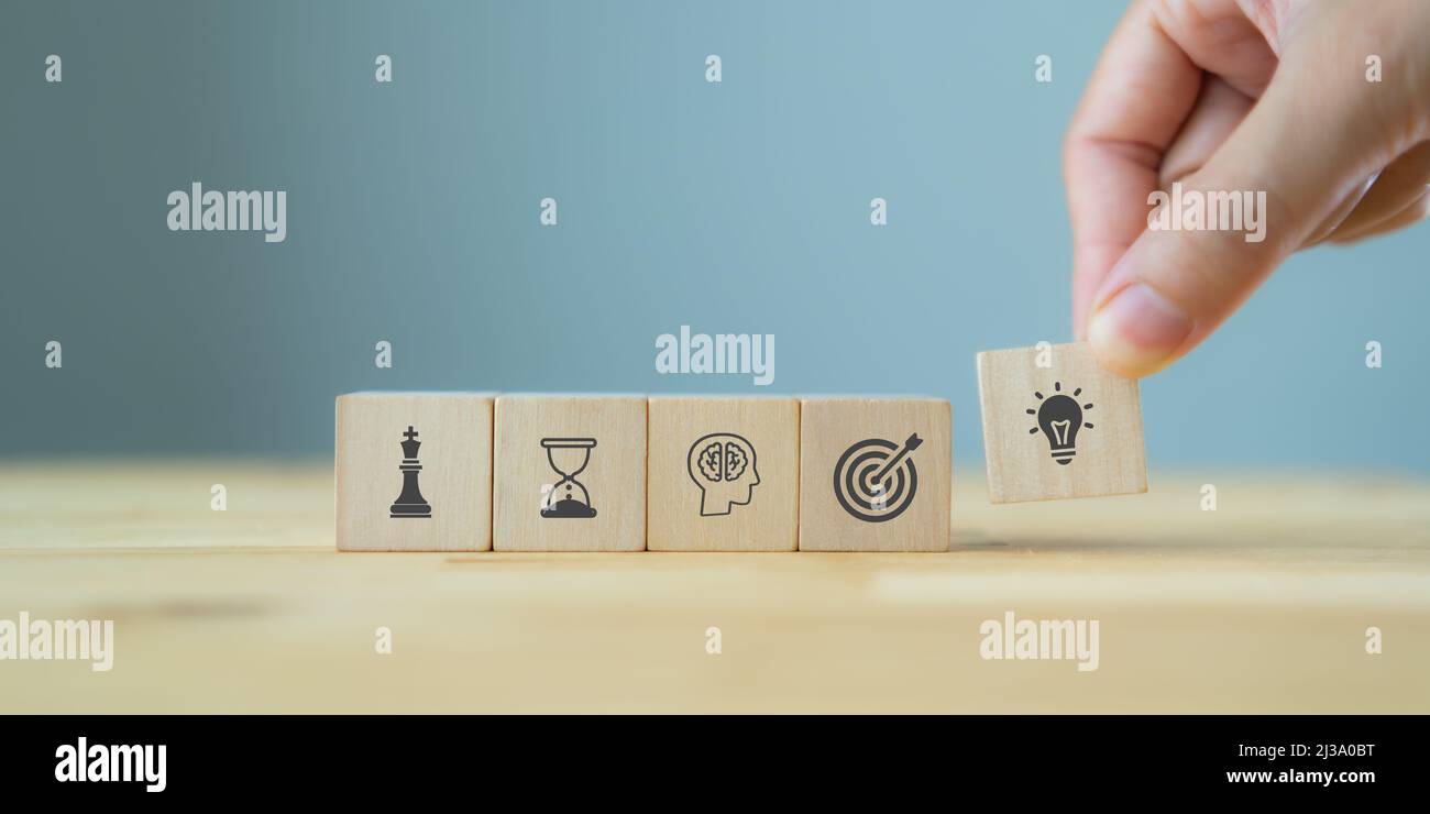 Uomo di affari mano che organizza legno blocco. Icona di strategia di affari compreso elemento con obiettivo, idea, leadership, gestione del tempo, conoscenza, Initi Foto Stock