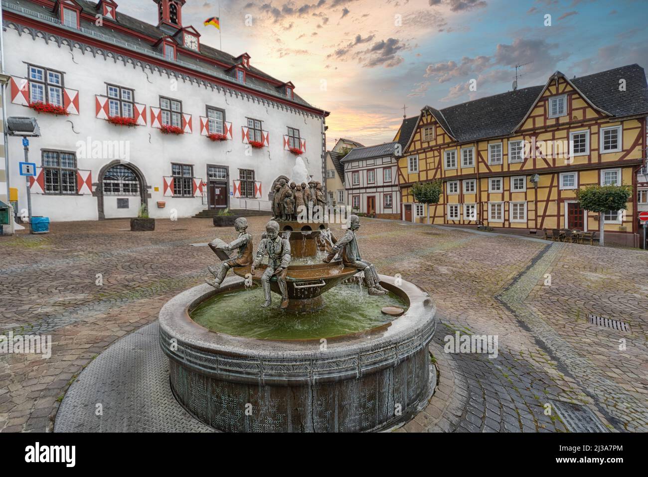 Fontana in rame nel mezzo del vecchio mercato con case a graticcio e il municipio sullo sfondo a Linz am Rhein, Germania. Foto Stock