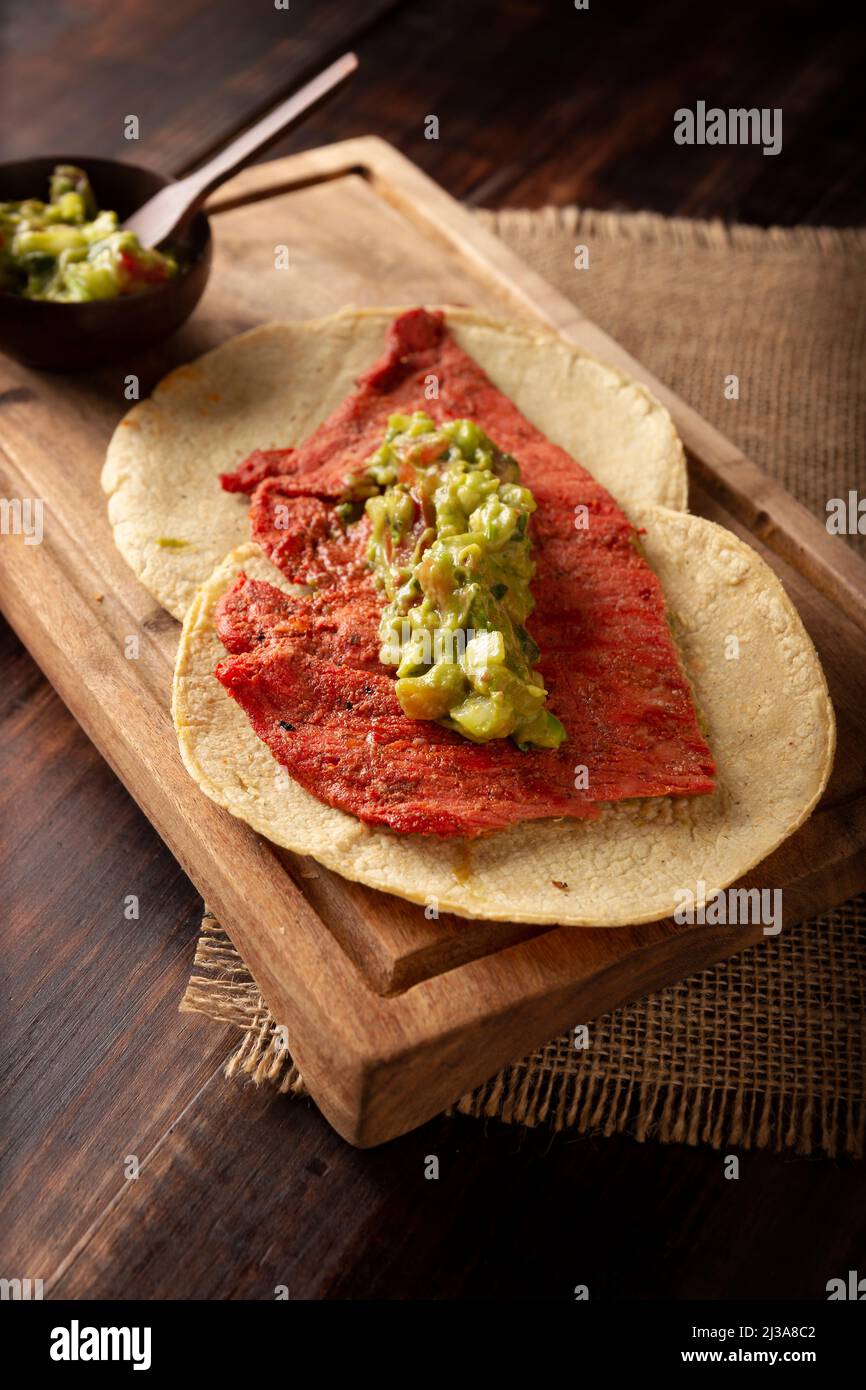 Taco de Cecina enchilada con Guacamole. Carne di maiale o di manzo salata, essiccata al sole, condita con varie spezie e peperoncini, solitamente mangiata in tacos Foto Stock