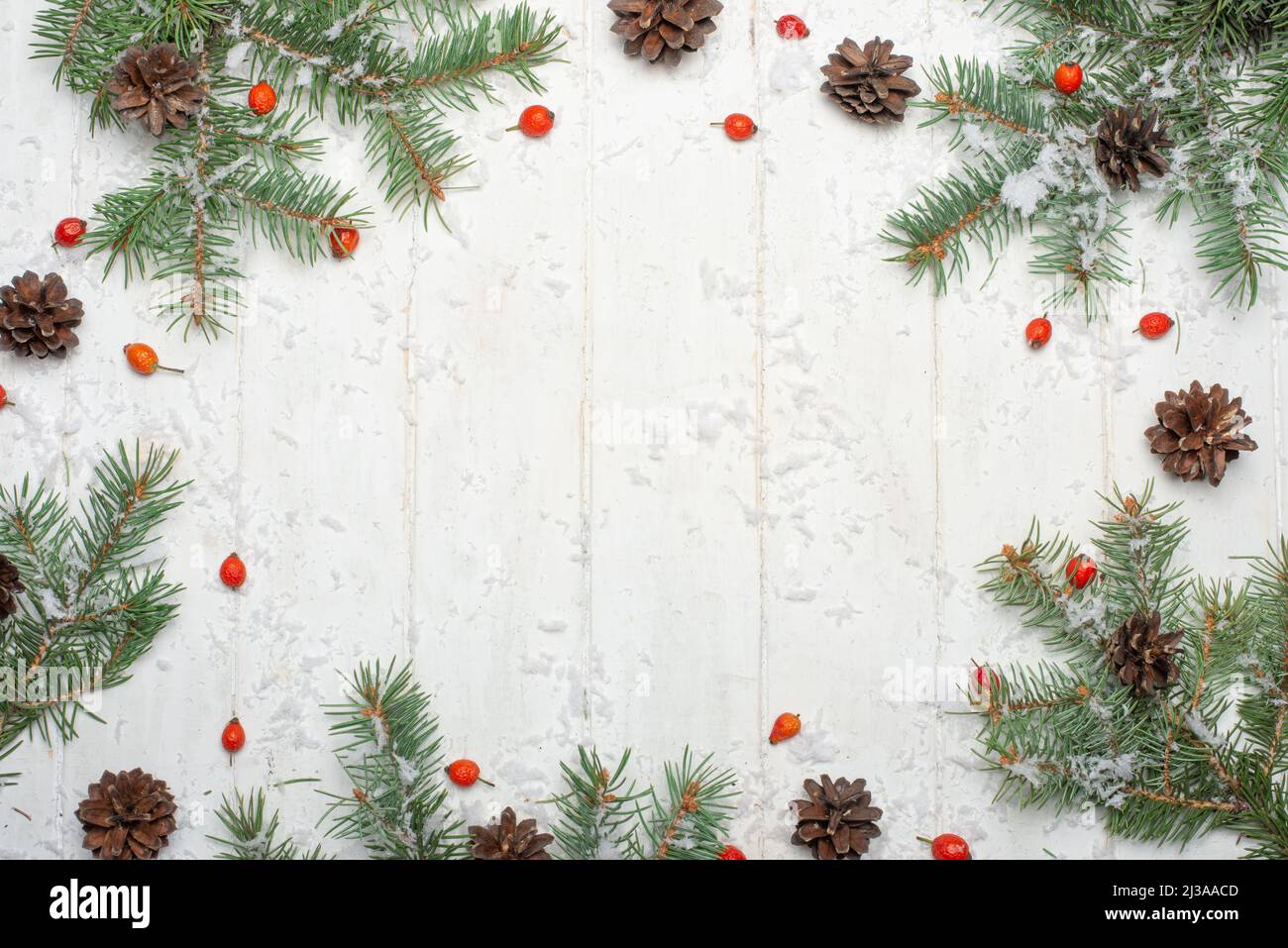 Telaio di Natale fatto di rami di abete, bacche rosse. Sfondo di natale. Appartamento laico, vista dall'alto, spazio di copia Foto Stock