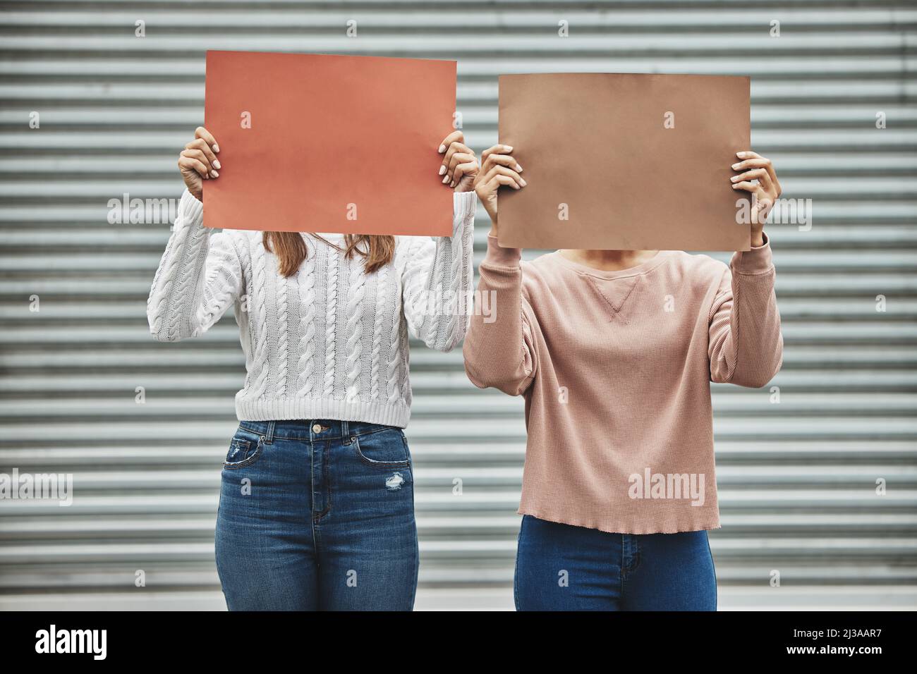 Alzate la voce. Un'immagine ritagliata di due donne irriconoscibili che hanno dei segni mentre prendono parte ad un raduno politico. Foto Stock