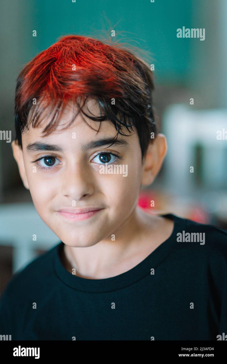 Un ritratto di un ragazzo argentino sorridente con un look alla moda su sfondo sfocato Foto Stock