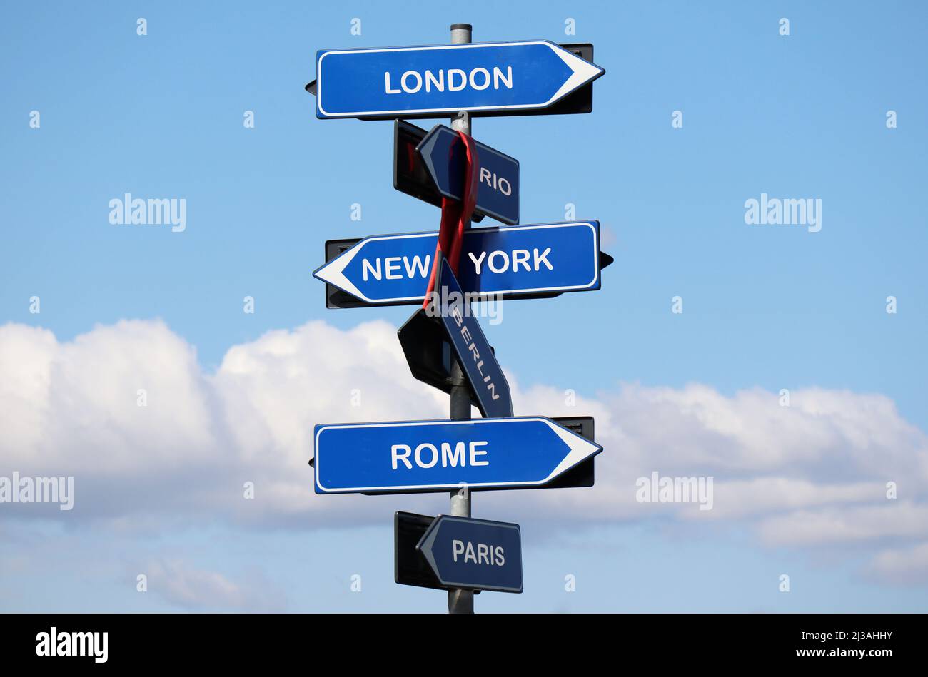 Segnaletica stradale con nomi di capitali isolati su sfondo cielo blu. Londra, New York, Roma, Parigi, Rio, Berlino. Foto Stock