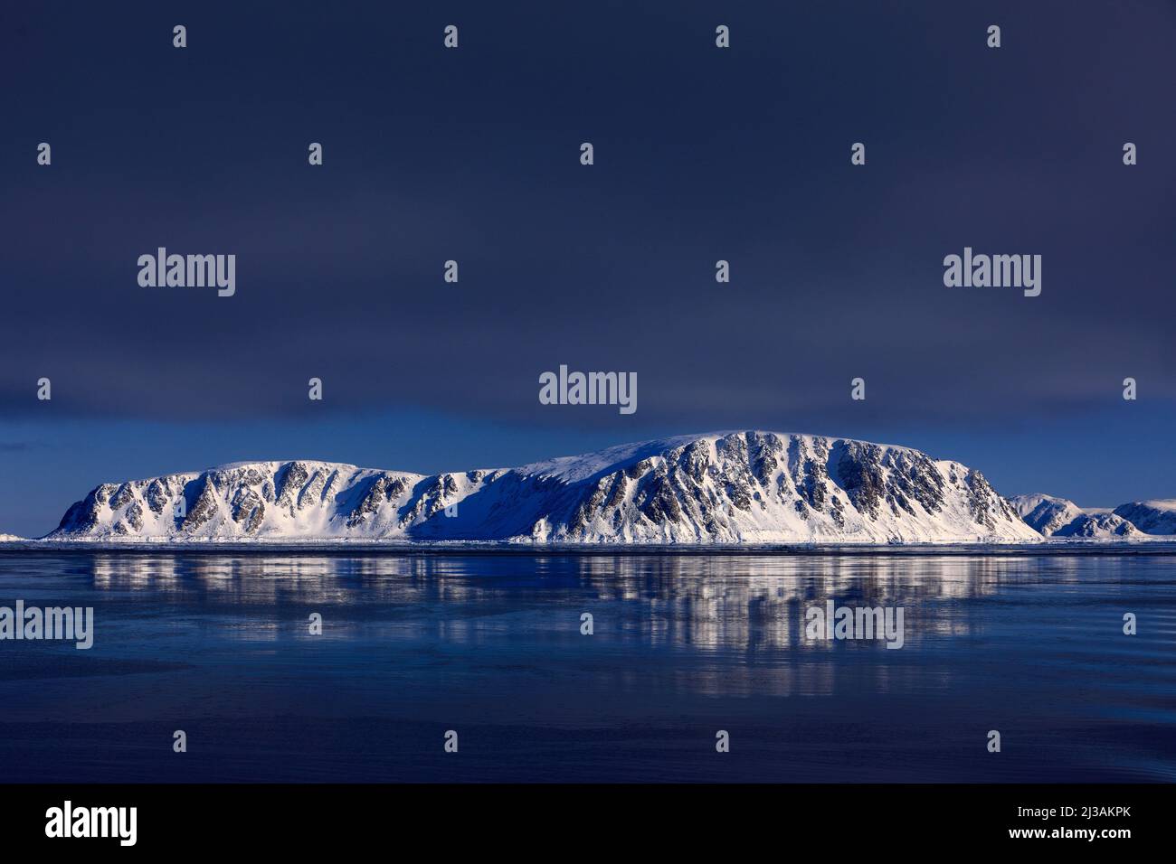 Montagna bianca innevata, ghiacciaio blu Svalbard, Norvegia. Ghiaccio in oceano. Iceberg crepuscolo, oceano. Nuvole rosa con ghiaccio galleggiante. Bellissimo paesaggio. Terra di ic Foto Stock