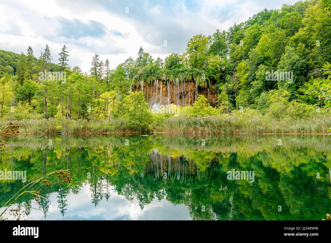La cascata di Veliki Prstavac si riflette nel lago Potok Plitvice del Parco Nazionale di Plitvice in Croazia. Patrimonio mondiale dell'UNESCO della Croazia di nome Plitvicka Foto Stock