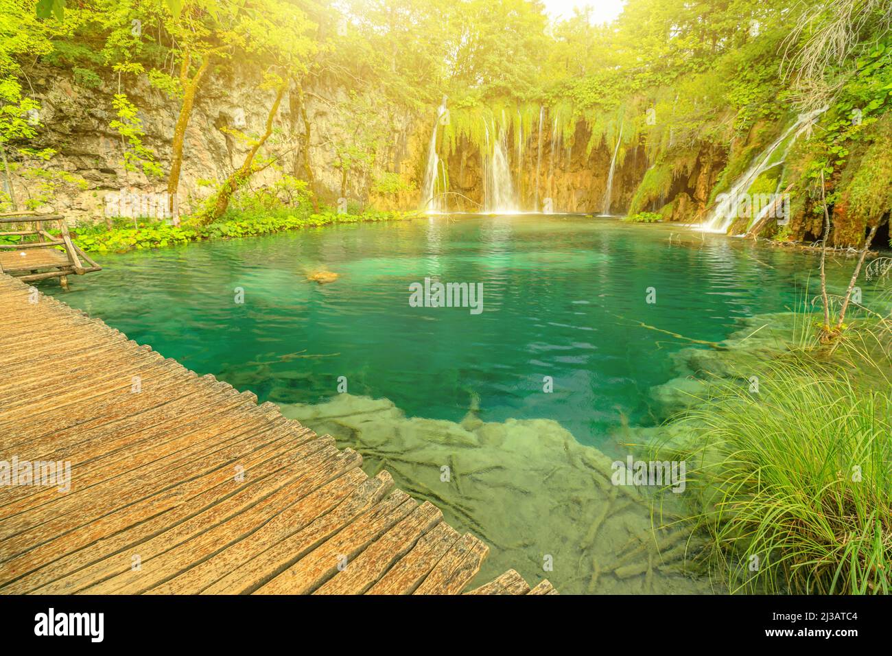 Sole sugli alberi sottomarini della cascata Galovacki Buk del Parco Nazionale di Plitvice in Croazia. Lago e foresta di Milino Jezero nella regione di Lika. UNESCO Foto Stock