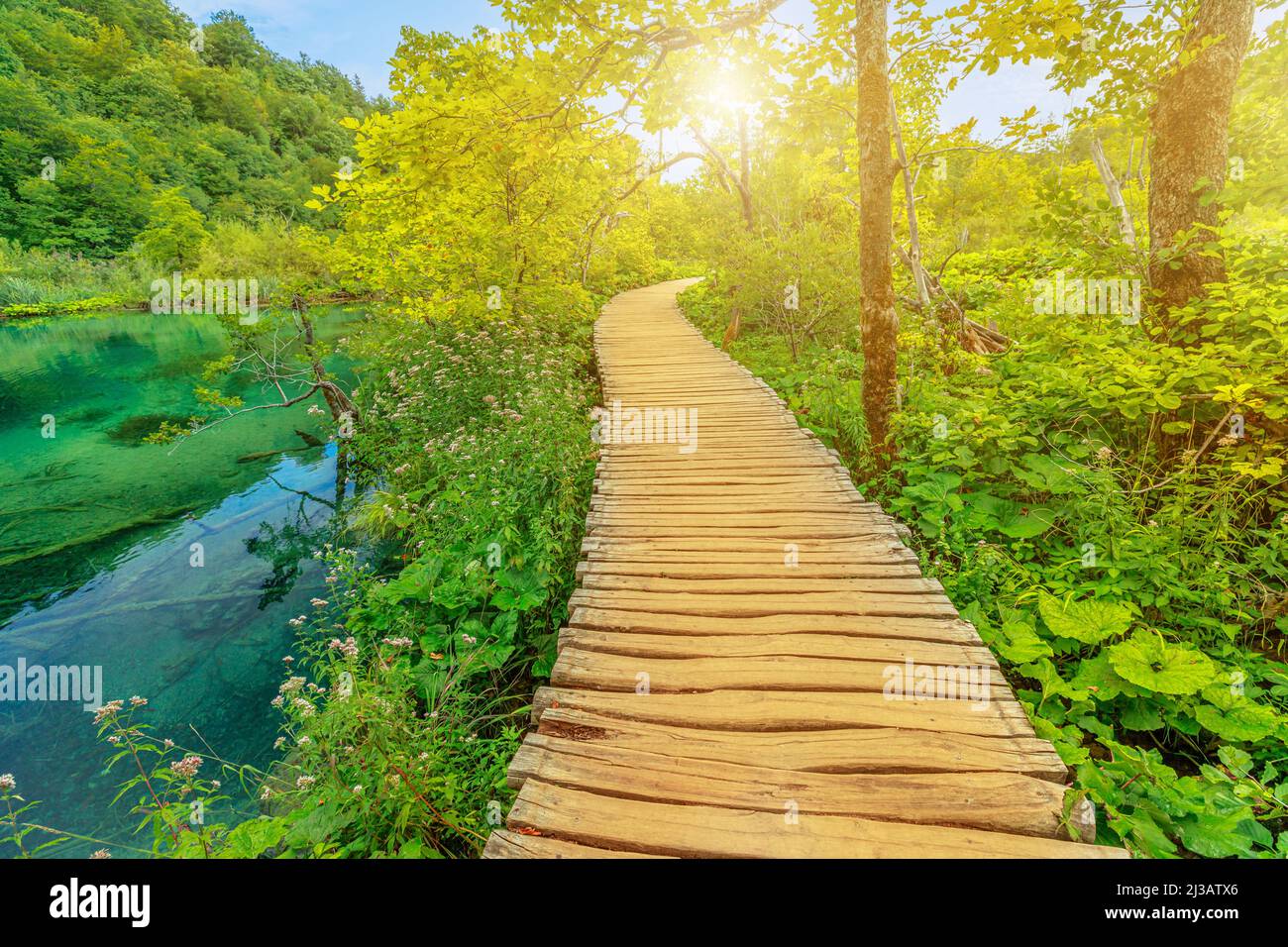 Camminando sul molo sotto le cascate sul lago Milino Jezero. Parco Nazionale dei Laghi di Plitvice in Croazia nella regione di Lika. Patrimonio mondiale dell'UNESCO di Foto Stock