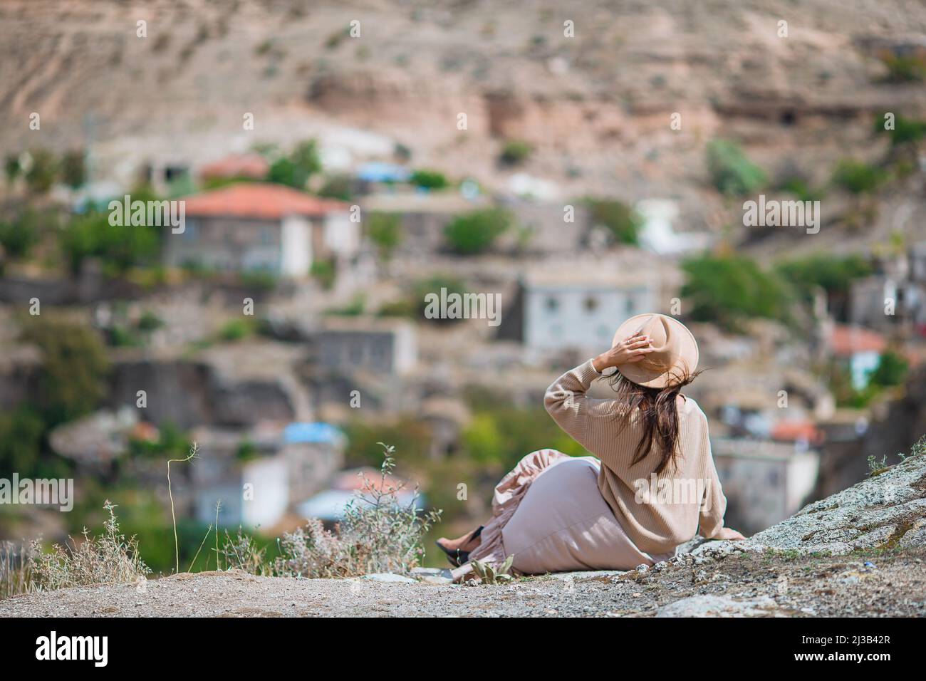 Giovane donna sullo sfondo di antiche formazioni rupestri in Cappadocia, Turchia. Il Monastero è uno dei più grandi edifici religiosi. Foto Stock