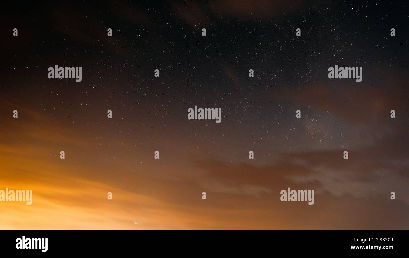 Tramonto sera cielo luminoso e stelle incandescenti. Sfondo naturale nei colori giallo e nero. CopySpace. Stelle dello spazio Starlight cielo stellato Foto Stock