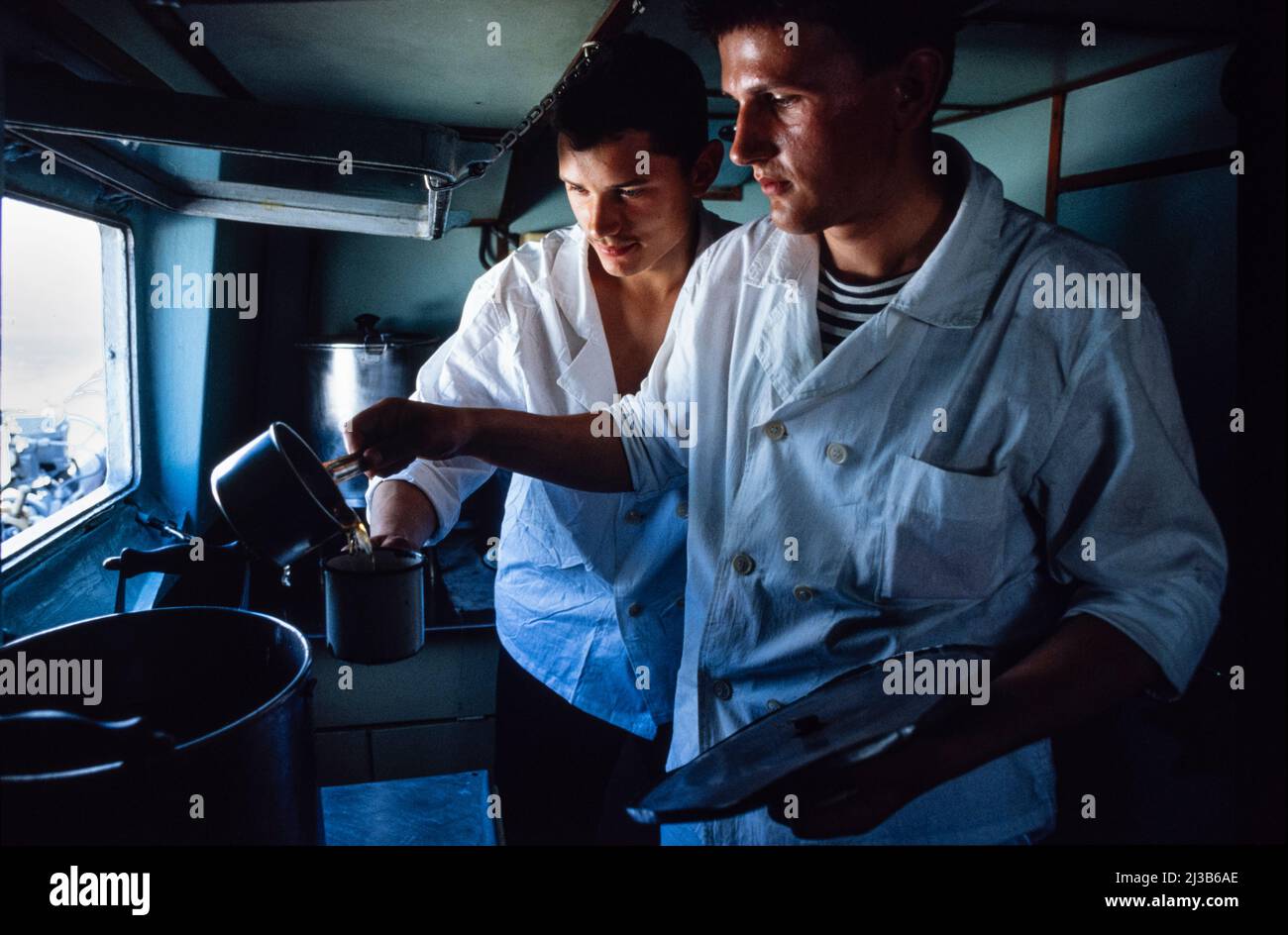 Giovane cuoco navale a bordo di una nave di bordo del KGB nella cucina sul Mar Nero, la Crimea, URSS, agosto 1990 Foto Stock
