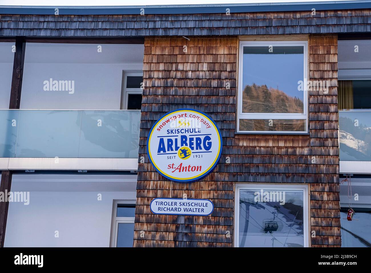 Insegna con il logo dell'azienda accanto alle finestre in vetro sulle pareti dell'edificio Foto Stock