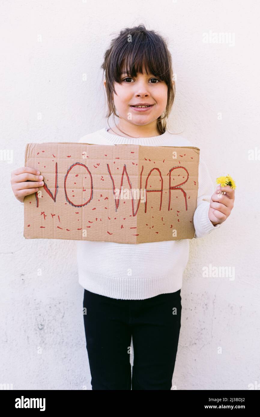 Piccola ragazza attivista anti-guerra che ha un segno che dice 'NO WAR'. Concetto di guerra, confronto, attivismo, pace e amore. Foto Stock