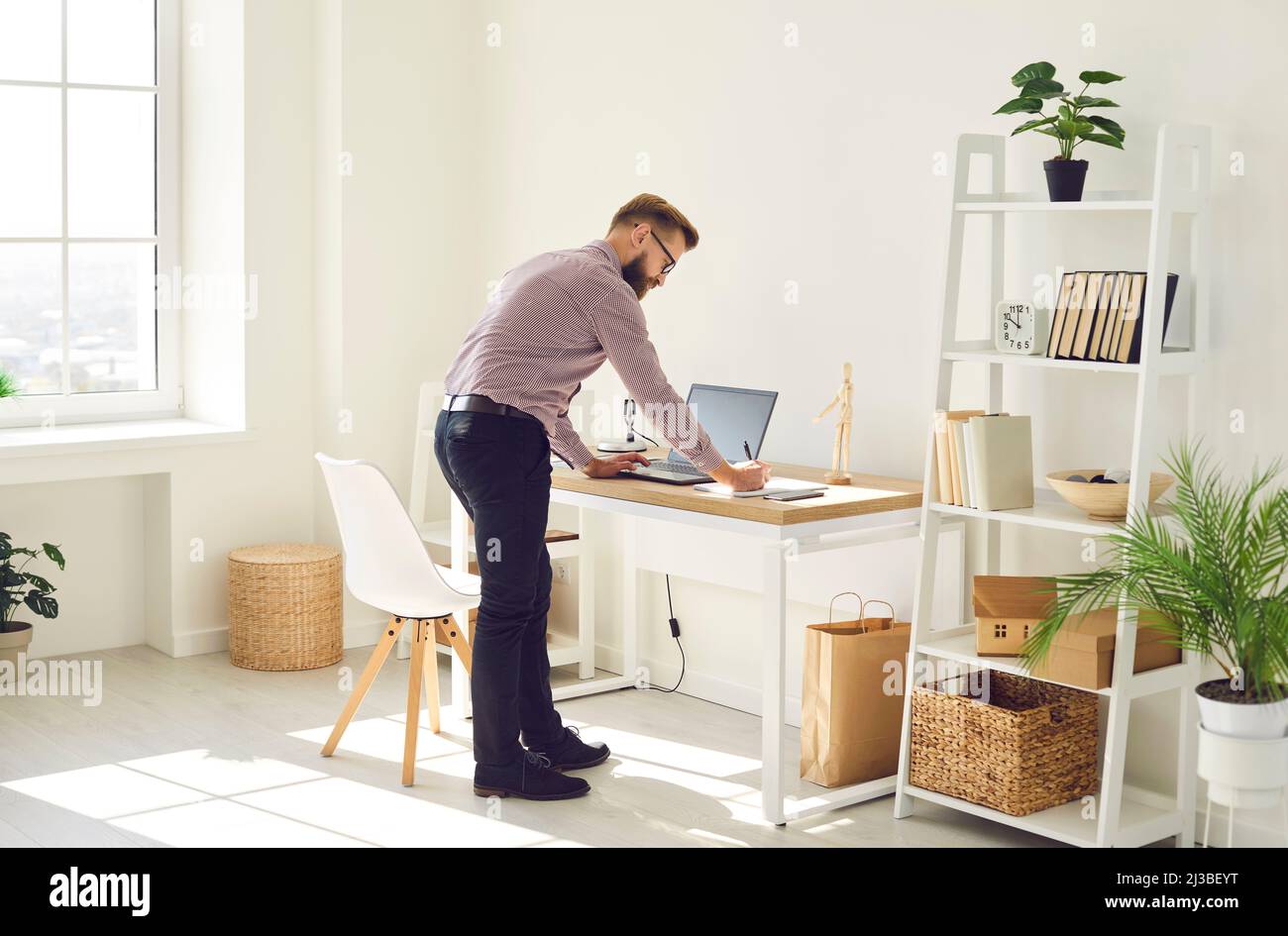 Un uomo d'affari lavora online su un notebook in ufficio Foto Stock