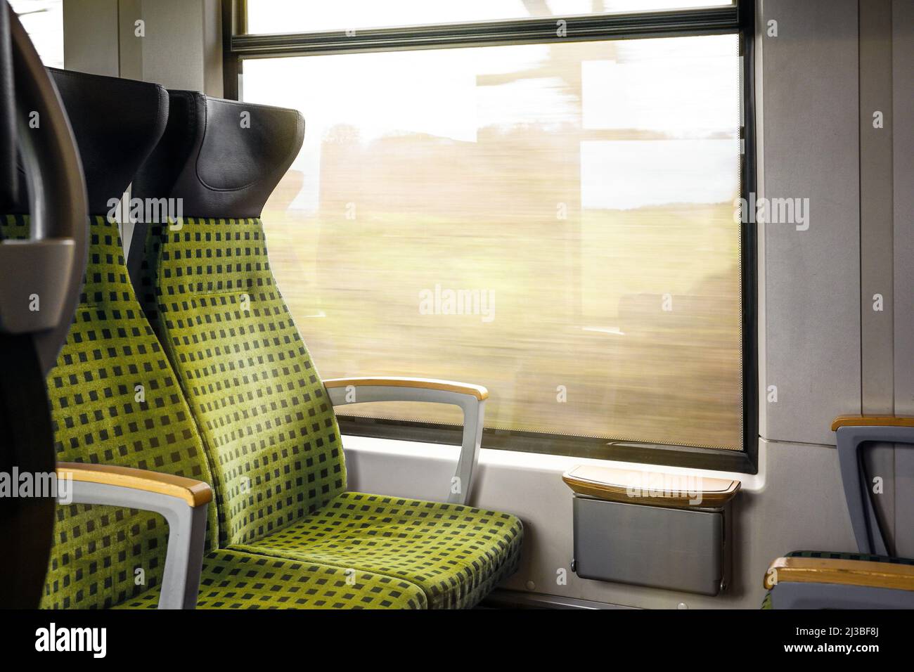 Sedili imbottiti accanto alla finestra all'interno di un treno in movimento, concetto di traffico, trasporto e viaggi, spazio copia, fuoco selezionato Foto Stock
