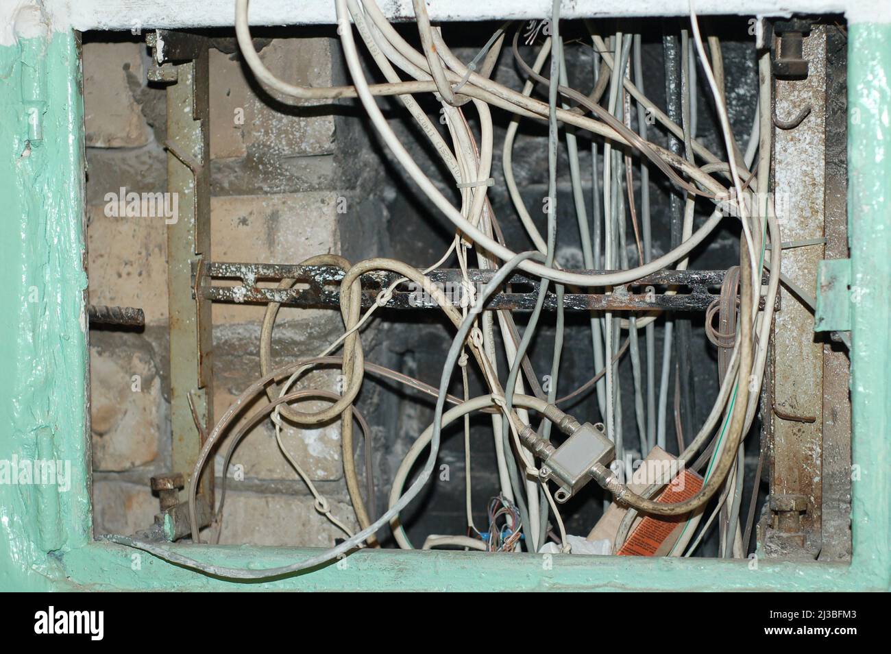 Concetto di reti elettriche e sicurezza - quadro elettrico con fili intrecciati in un edificio di appartamenti russo. Foto Stock
