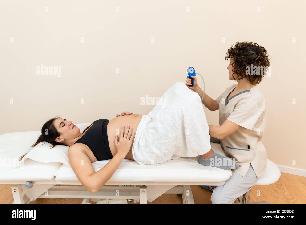 Ginecologo in possesso di un apparato muscolo pelvico del pavimento esercizio per preparare per la nascita di una donna Foto Stock