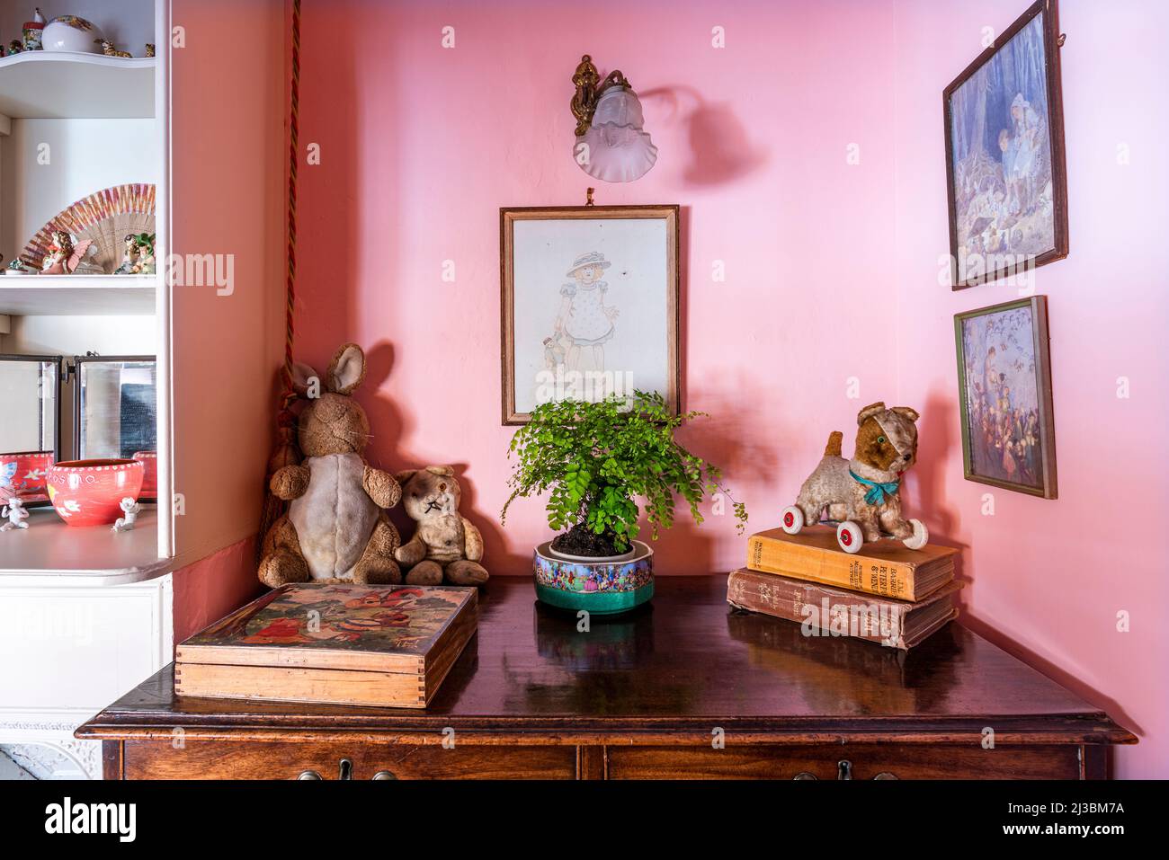 Giocattoli e libri su cassettiere in legno nella stanza del bambino, 17th secolo Suffolk casa, Regno Unito Foto Stock
