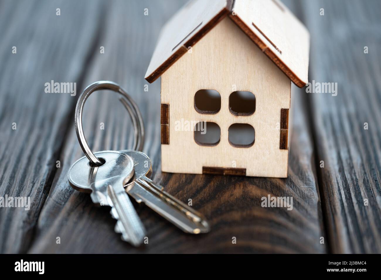 Piccola casa giocattolo con le chiavi sulle tavole di legno marrone Foto Stock