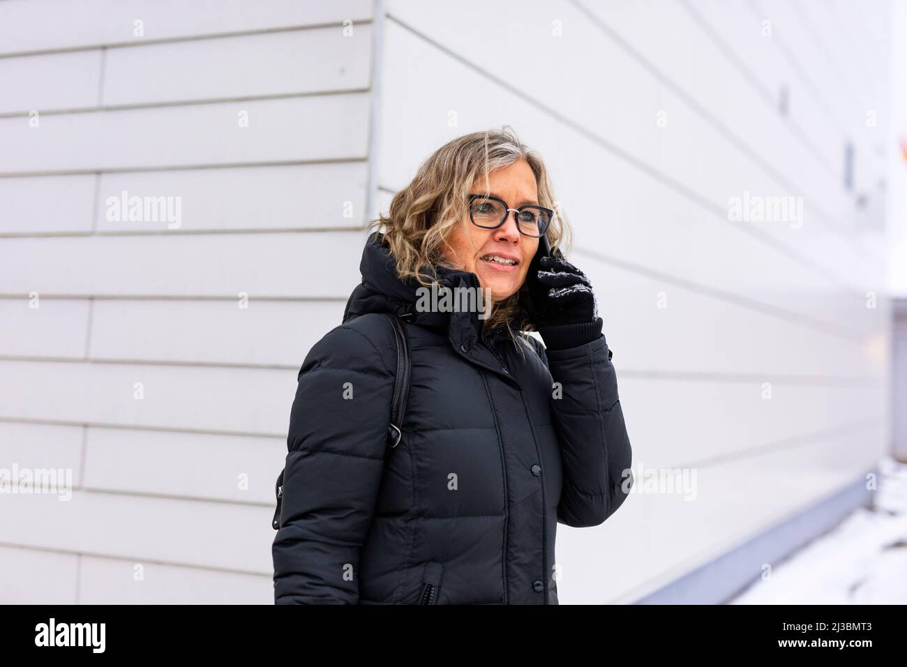 Donna anziana che parla al telefono all'aperto Foto Stock