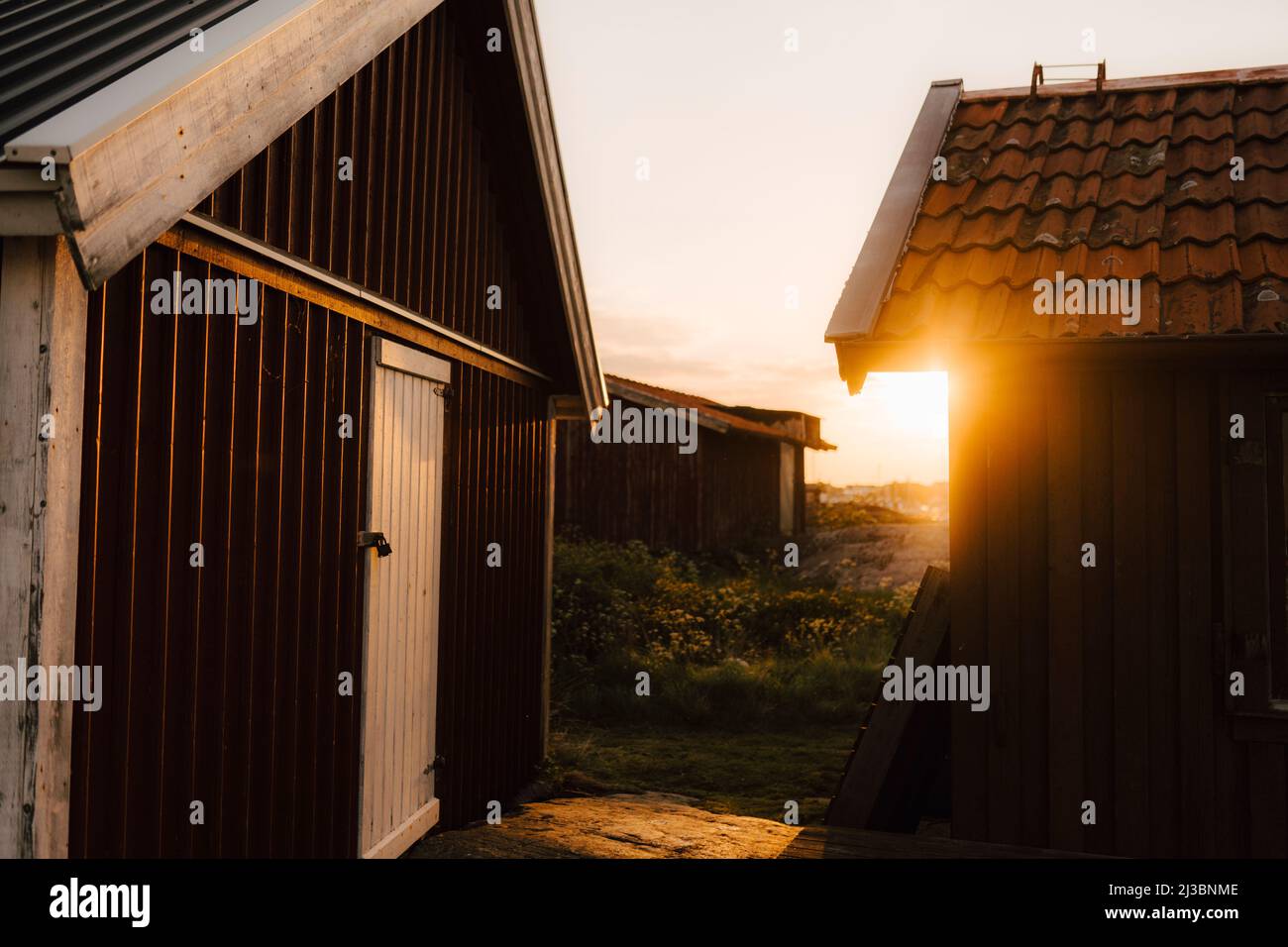 Vecchie capannoni di legno al tramonto Foto Stock
