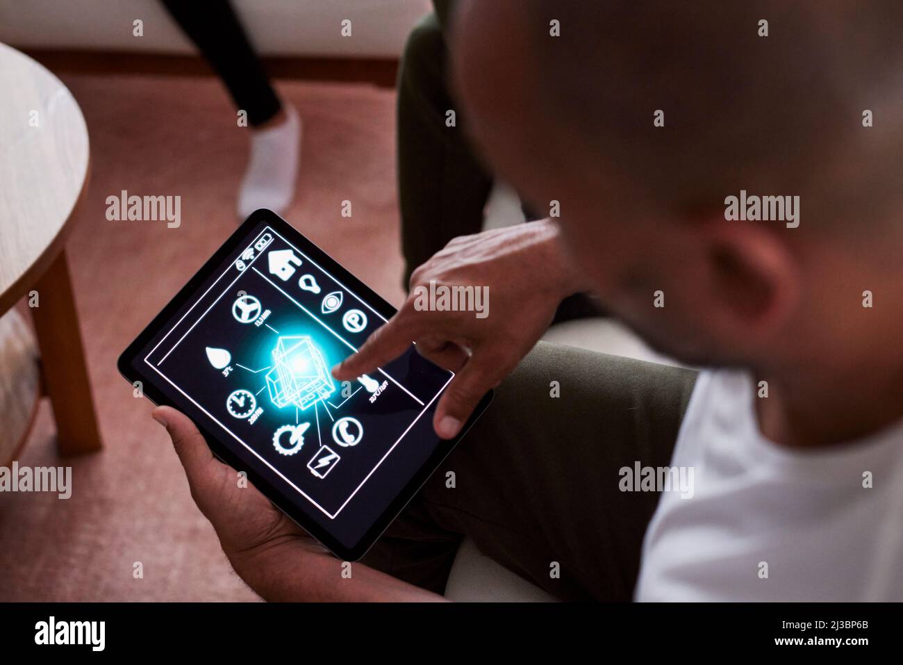 Uomo che utilizza l'applicazione per la casa intelligente sul tablet Foto Stock
