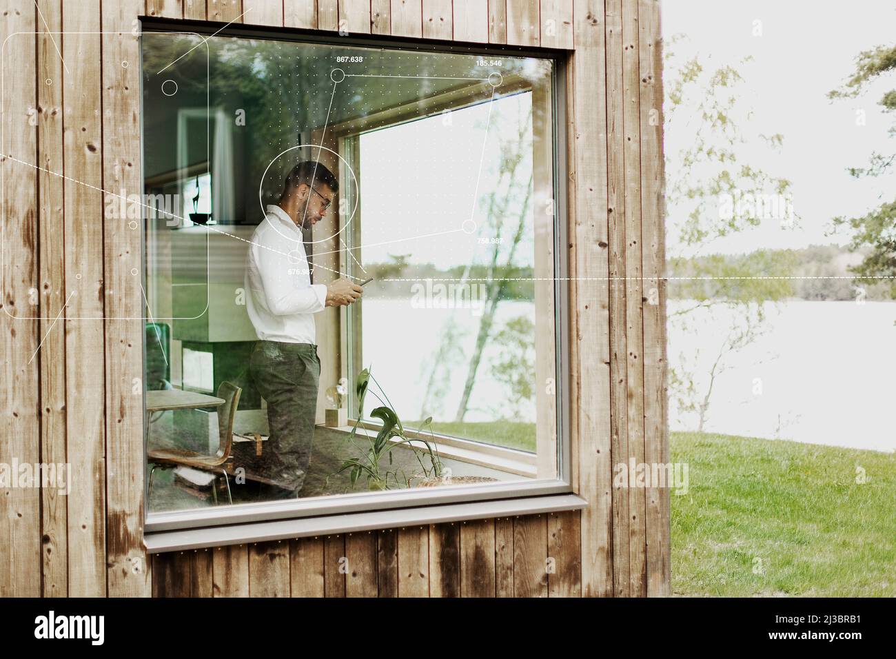 Uomo che usa lo smartphone in cottage fine settimana Foto Stock