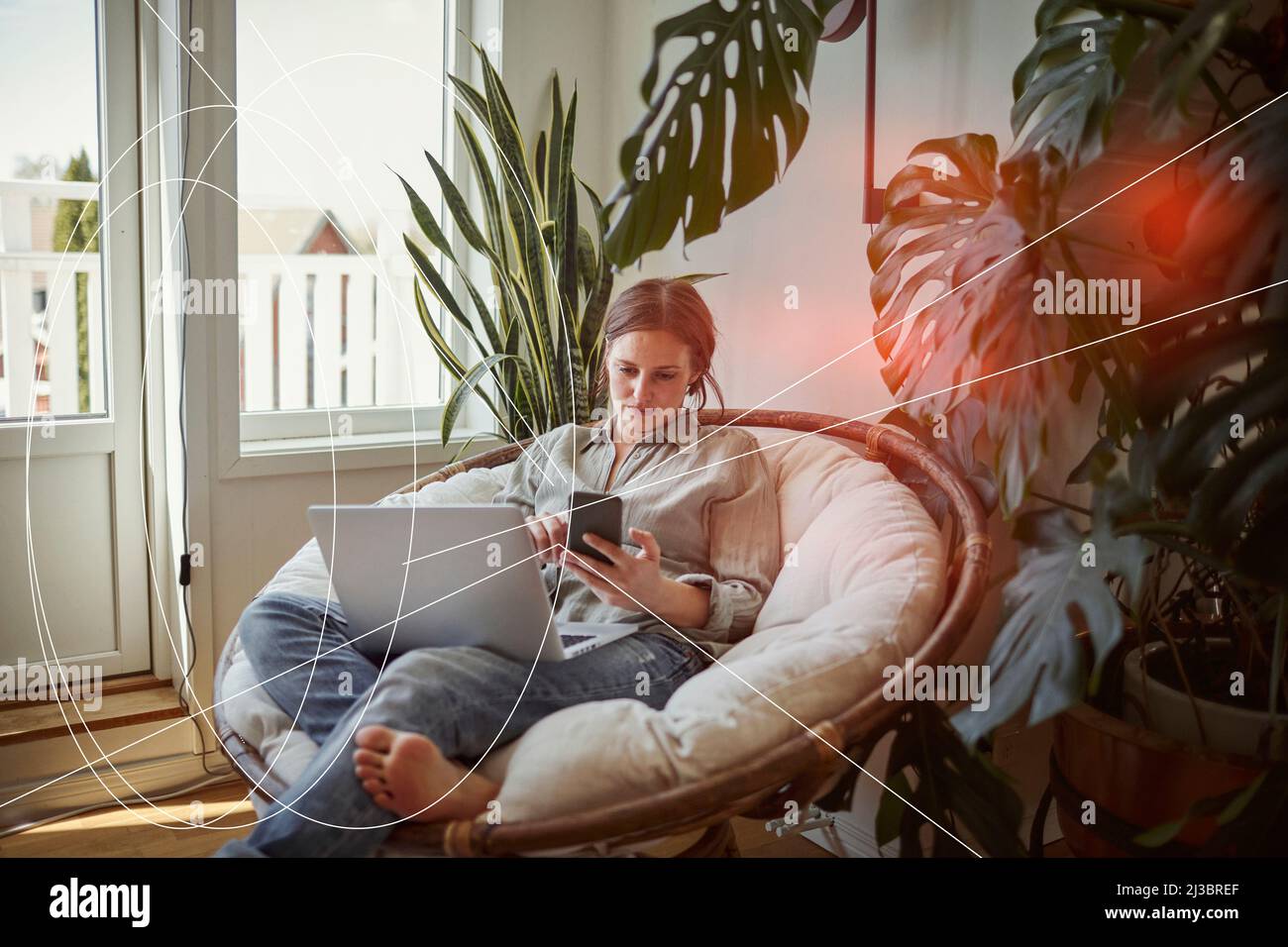 Donna che usa smartphone e laptop a casa Foto Stock