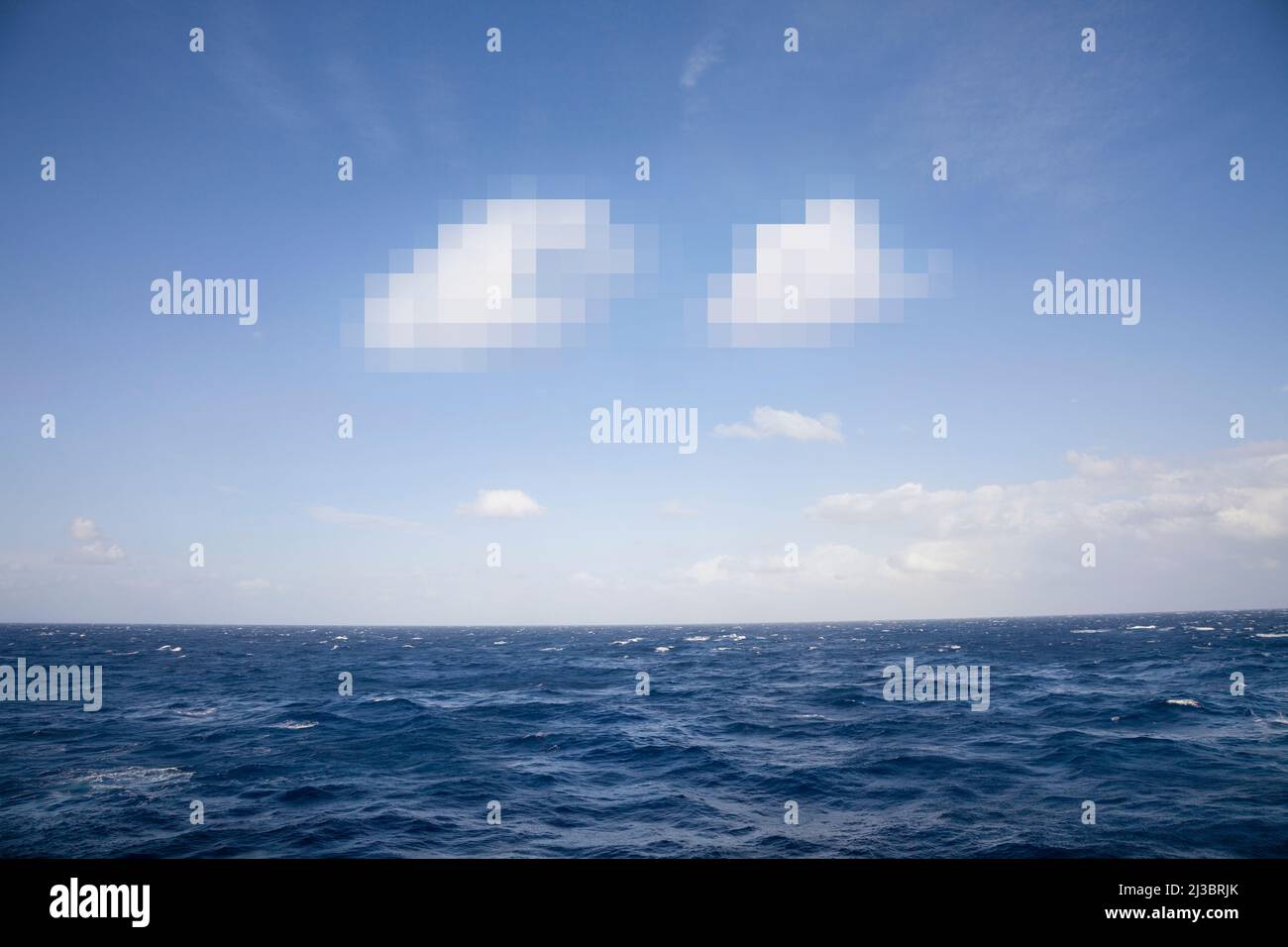 Nuvole pixelate nel cielo blu e nel mare Foto Stock