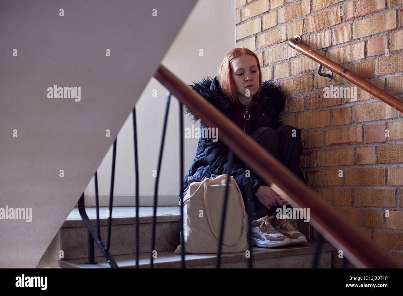 Giovane donna seduta sulle scale Foto Stock