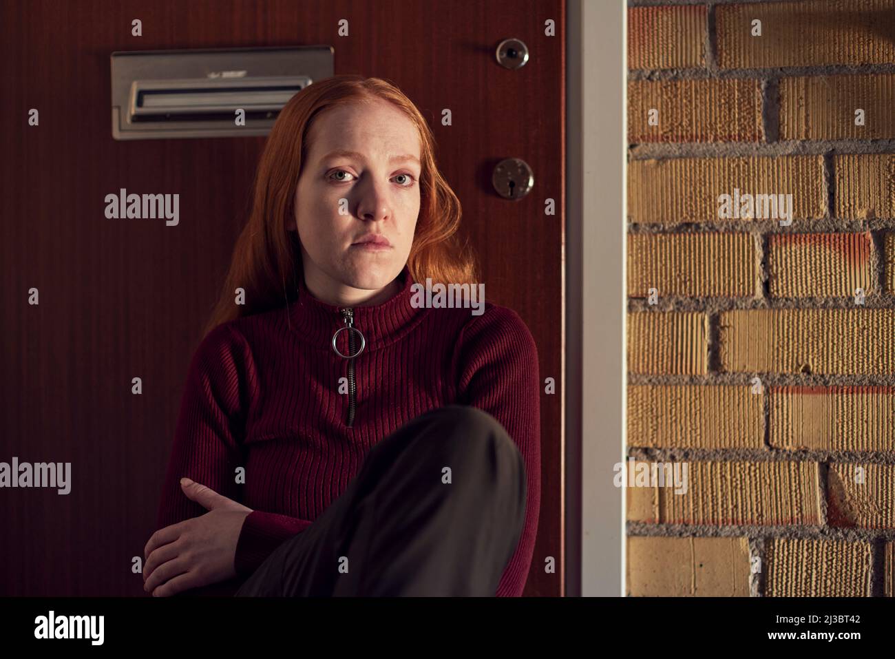 Ritratto di giovane donna rossa seduta sulle scale Foto Stock