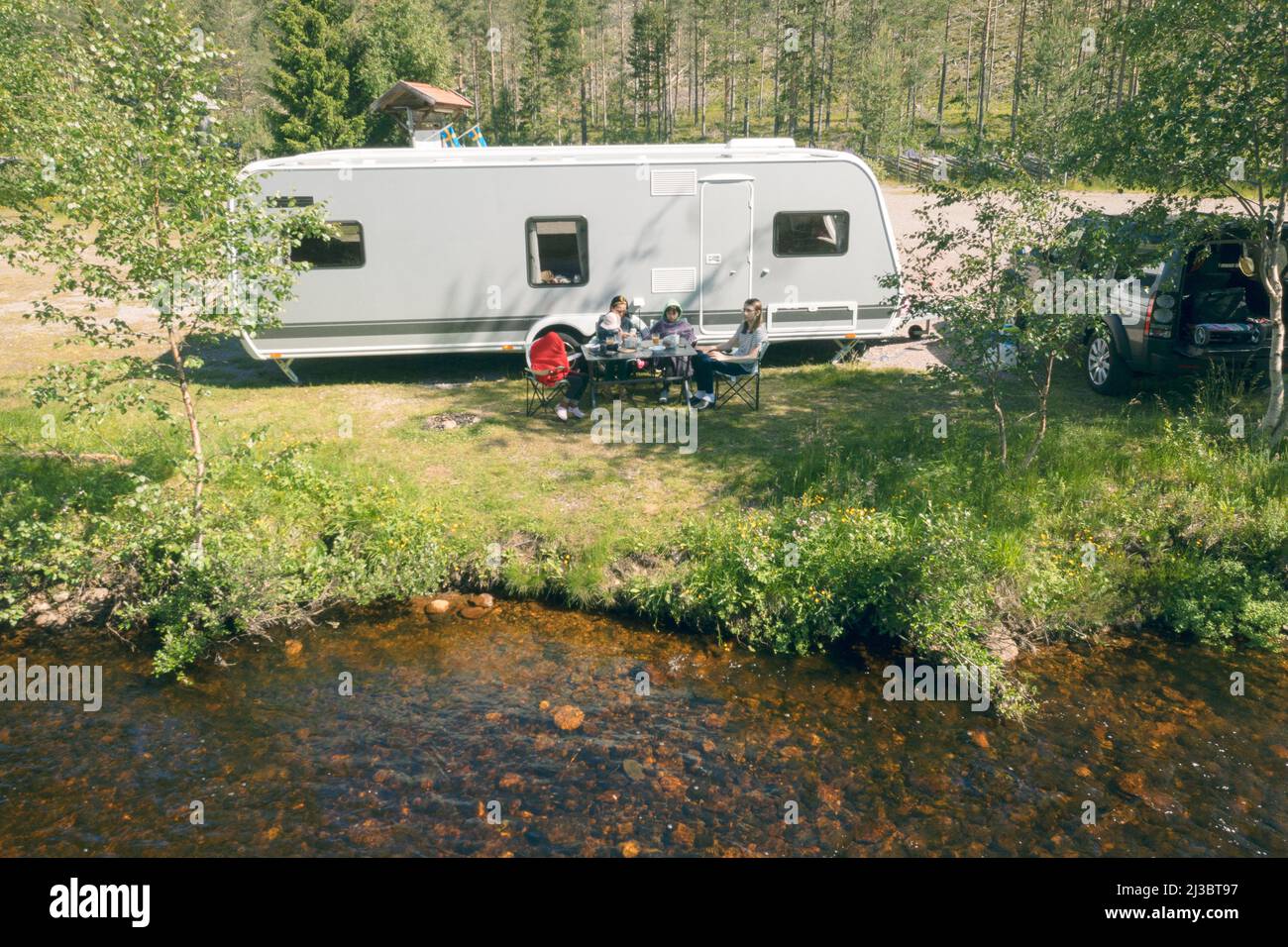 Relax in famiglia di fronte al camper trailer Foto Stock