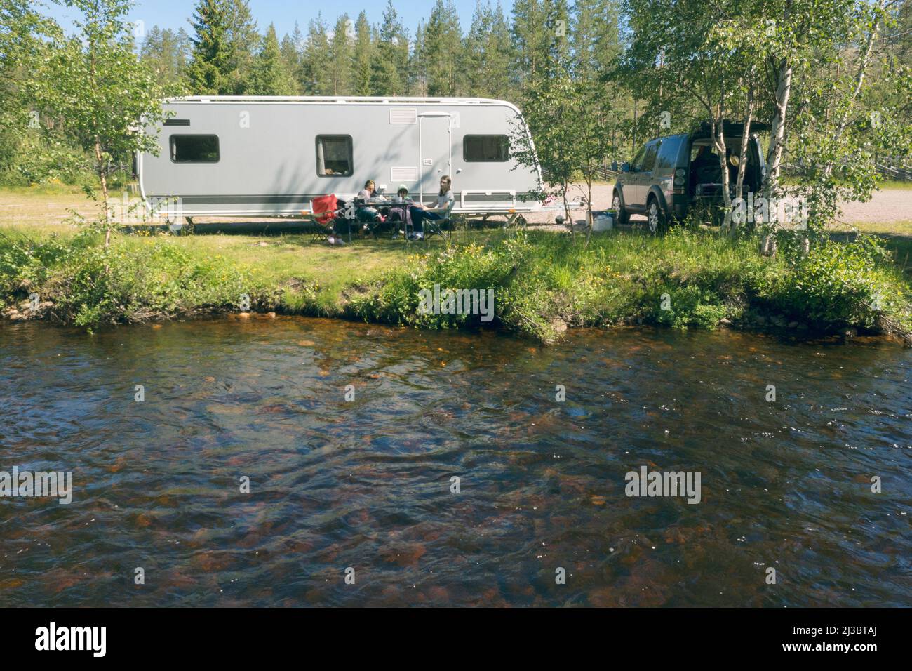 Relax in famiglia di fronte al camper trailer Foto Stock