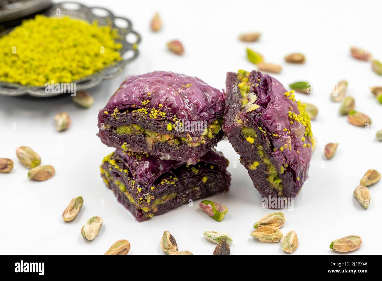 Pistacchio baklava viola su sfondo bianco. Baklava appositamente preparato per i diabetici. Specialità della cucina mediterranea tradizionale. Primo piano Foto Stock