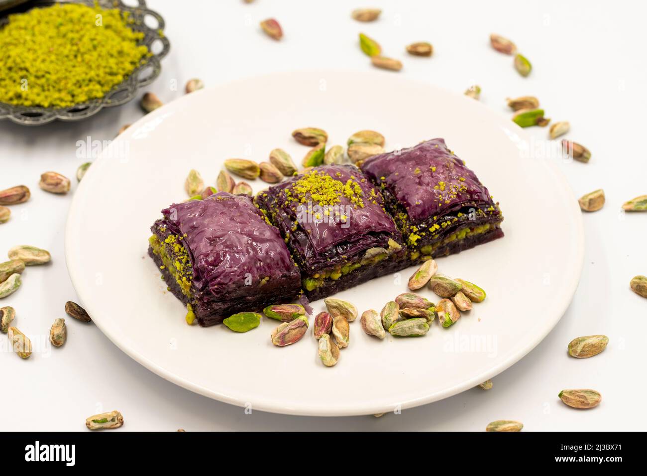 Pistacchio baklava viola su sfondo bianco. Baklava appositamente preparato per i diabetici. Specialità della cucina mediterranea tradizionale. Primo piano Foto Stock